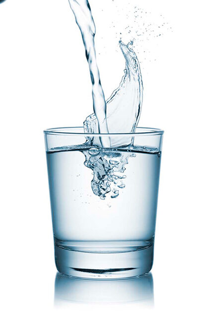 Rellenando de agua un vaso de cristal